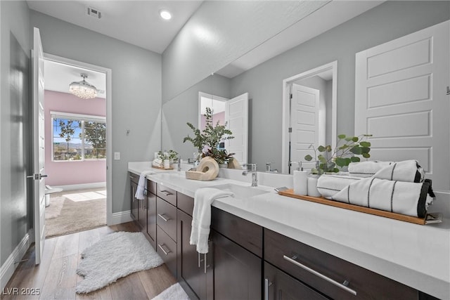 bathroom featuring visible vents, baseboards, recessed lighting, wood finished floors, and vanity