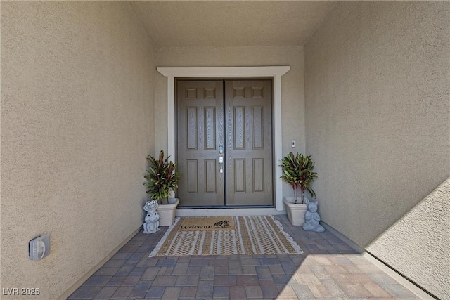 view of exterior entry featuring stucco siding