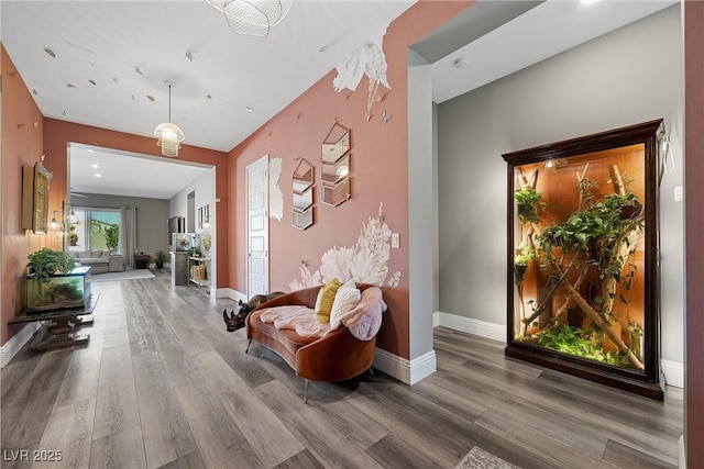 hallway featuring wood finished floors and baseboards