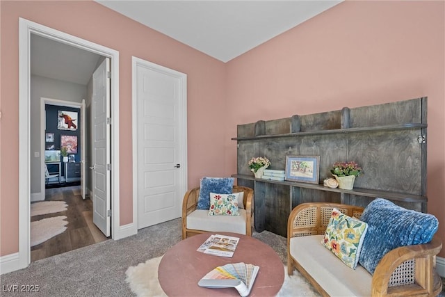 living area featuring baseboards and carpet