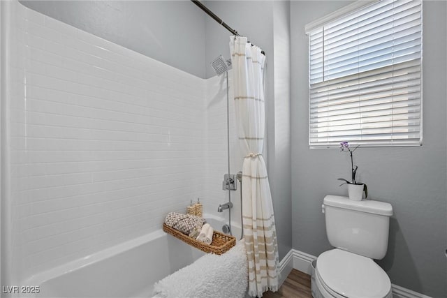 bathroom featuring wood finished floors, toilet, baseboards, and shower / bathtub combination with curtain