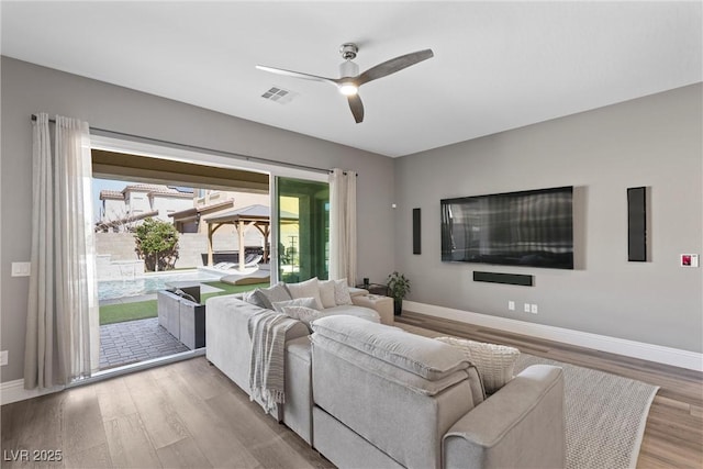 living room with visible vents, baseboards, ceiling fan, and wood finished floors