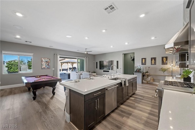 kitchen with visible vents, dark brown cabinets, light countertops, a wealth of natural light, and appliances with stainless steel finishes