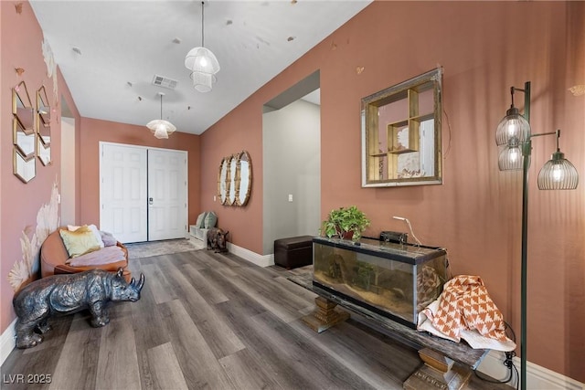 foyer entrance featuring wood finished floors, visible vents, and baseboards