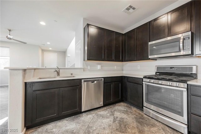 3158 Teaderman Walk, Henderson, NV 89044 - kitchen with appliances with stainless steel finishes, a sink, light countertops, a peninsula, and dark brown cabinets