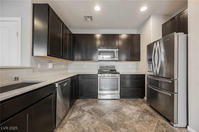 3158 Teaderman Walk, Henderson, NV 89044 - kitchen with stainless steel appliances, light countertops, dark brown cabinetry, stone finish flooring, and a sink