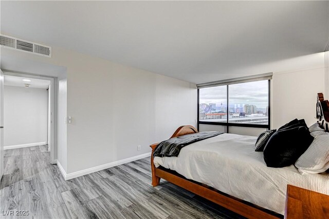 205 E Harmon Ave Unit 1010, Las Vegas, NV 89169 - bedroom featuring visible vents, baseboards, and wood finished floors