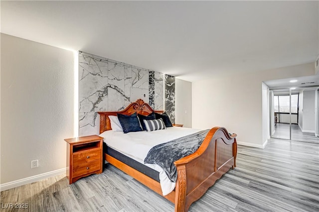 205 E Harmon Ave Unit 1010, Las Vegas, NV 89169 - bedroom with an accent wall, light wood-type flooring, and baseboards
