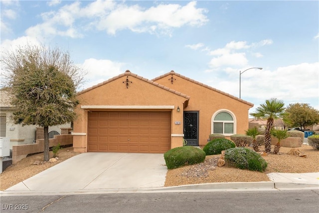 view of front of property with fence, a tile roof, stucco siding, a garage, and driveway