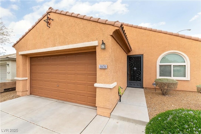 view of front of home with an attached garage, driveway, and stucco siding