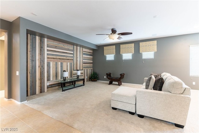 tiled living area featuring baseboards, carpet floors, and ceiling fan