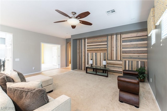 living area featuring visible vents, carpet floors, and ceiling fan