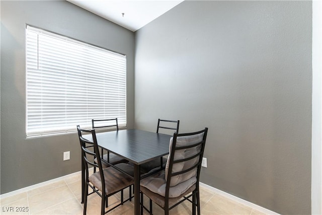 dining space with light tile patterned floors, plenty of natural light, and baseboards