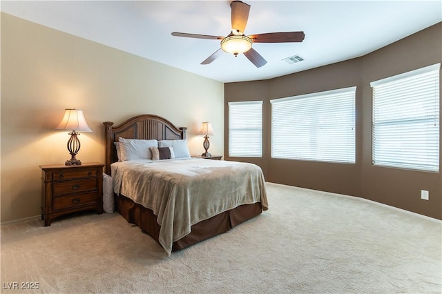 carpeted bedroom with visible vents and a ceiling fan