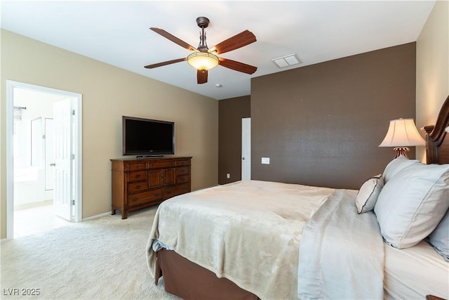 bedroom with visible vents, connected bathroom, baseboards, light colored carpet, and a ceiling fan