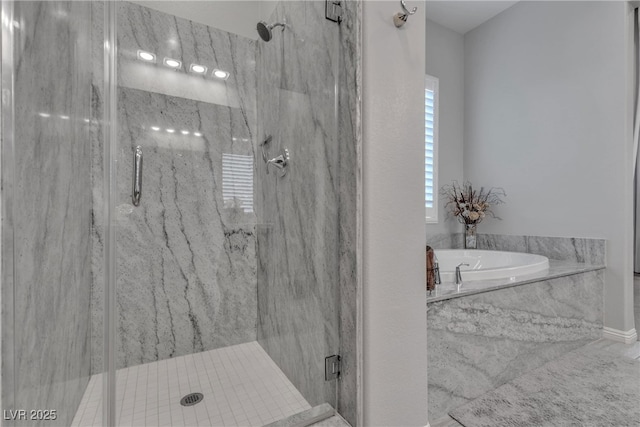 full bathroom featuring a marble finish shower and a garden tub