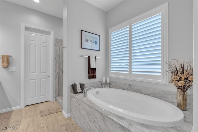 bathroom with a healthy amount of sunlight, a stall shower, and a garden tub