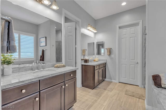 bathroom featuring vanity, baseboards, and walk in shower