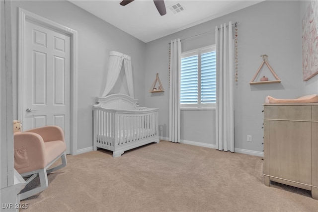 bedroom with visible vents, carpet flooring, a crib, and baseboards