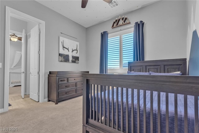 bedroom featuring ceiling fan, light colored carpet, visible vents, and baseboards