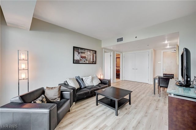 living area featuring light wood-style flooring and visible vents