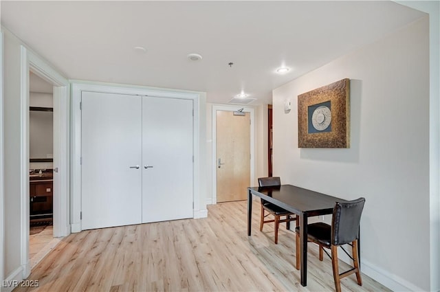 dining space with light wood-style flooring and baseboards