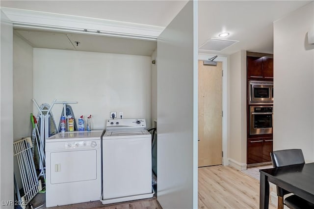 laundry room with laundry area, light wood-style floors, and washing machine and clothes dryer