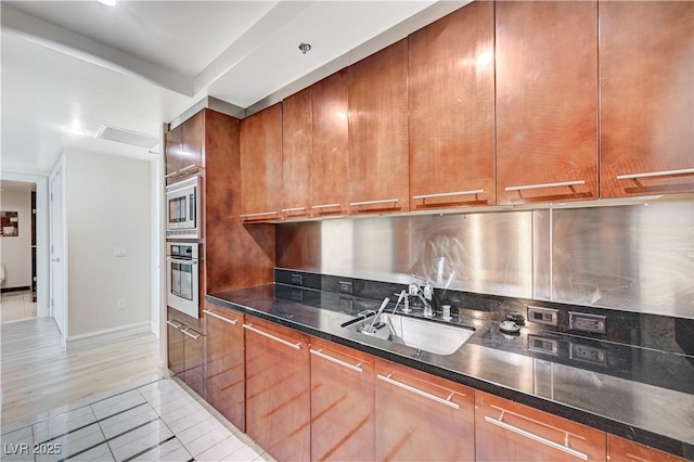 kitchen featuring light tile patterned floors, stainless steel appliances, modern cabinets, and a sink