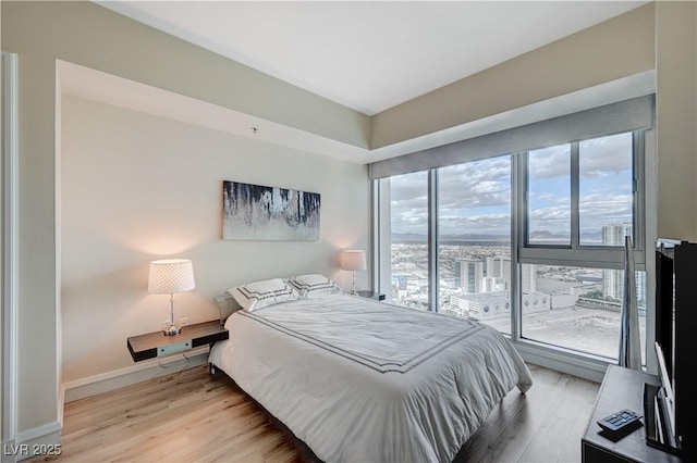 bedroom with baseboards and light wood-type flooring