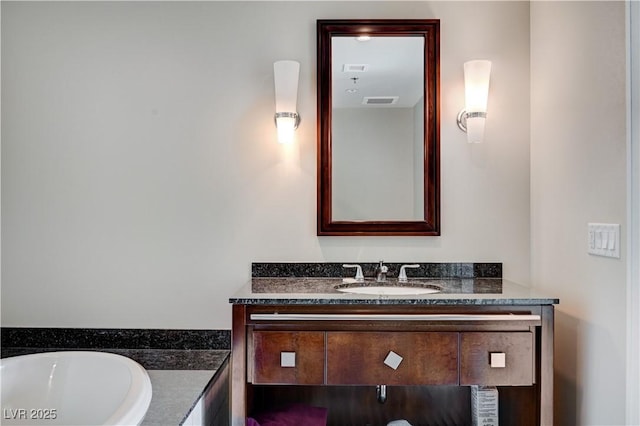 bathroom with a bathing tub, vanity, and visible vents