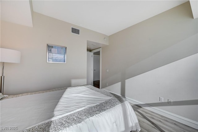 bedroom with visible vents and wood finished floors