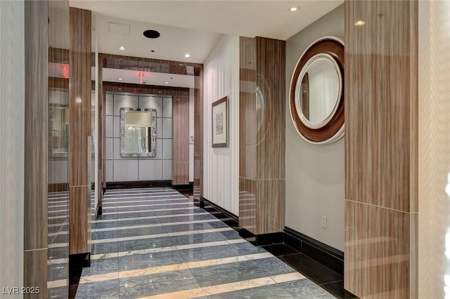 hall with recessed lighting and baseboards