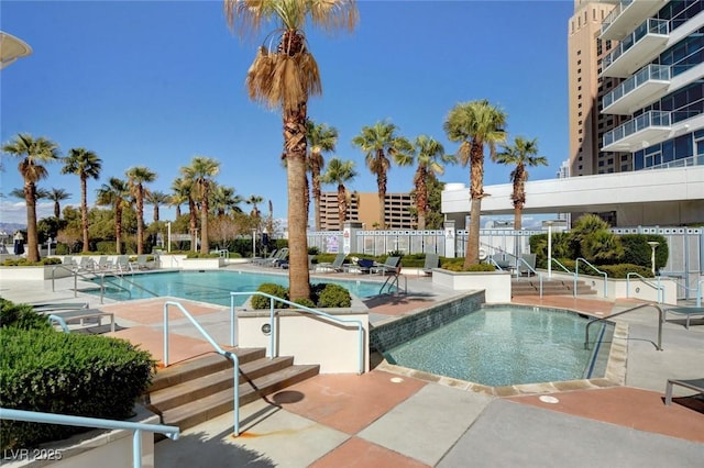 pool with a patio area and fence