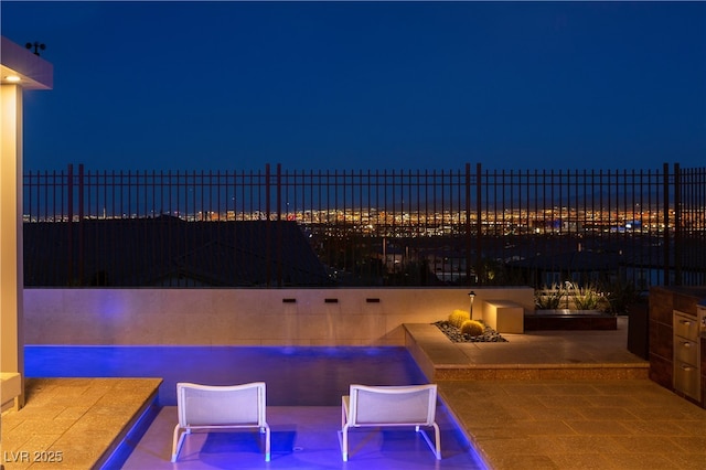 patio at twilight with a fenced in pool and fence