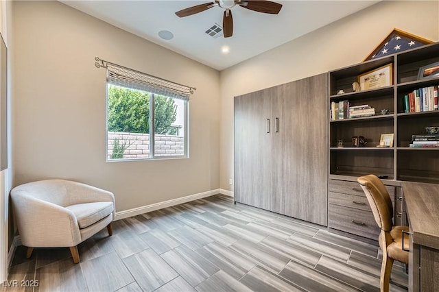 sitting room with visible vents, baseboards, and a ceiling fan