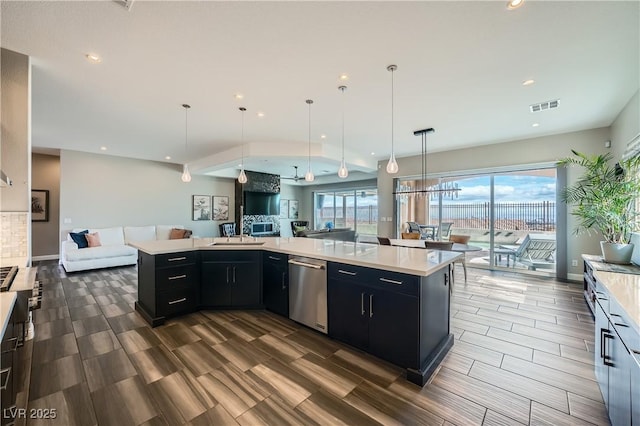 kitchen featuring open floor plan, dark cabinetry, visible vents, and stainless steel dishwasher