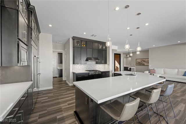 294 Besame Ct, Las Vegas, NV 89138 - kitchen featuring tasteful backsplash, a large island with sink, a sink, baseboards, and dark wood-type flooring