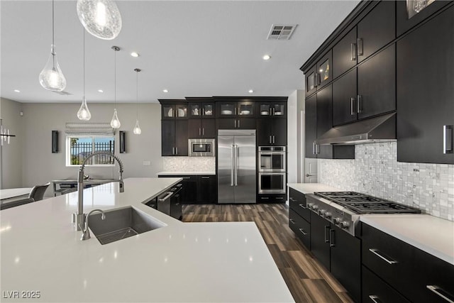 294 Besame Ct, Las Vegas, NV 89138 - kitchen with built in appliances, light countertops, under cabinet range hood, a sink, and dark wood finished floors