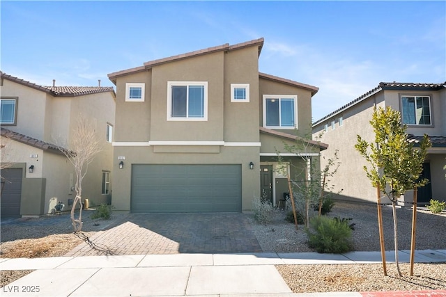 view of front facade with decorative driveway, a garage, and stucco siding