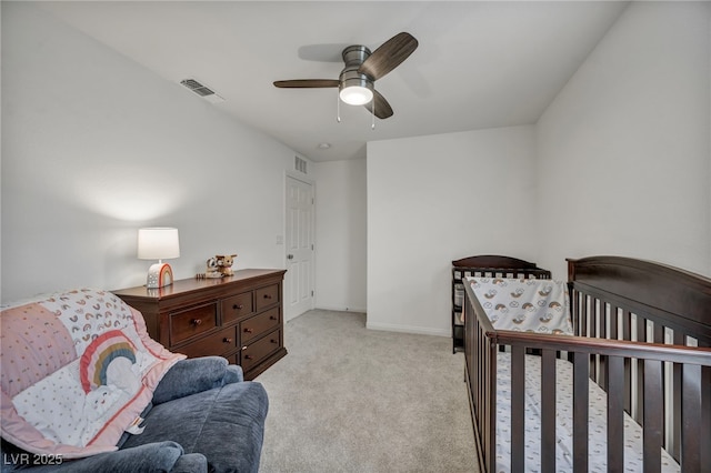 bedroom featuring visible vents, baseboards, light colored carpet, and a ceiling fan