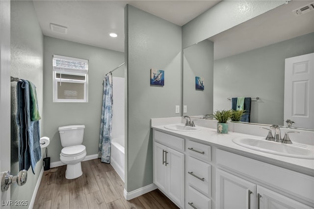 full bathroom featuring toilet, wood finished floors, visible vents, and a sink