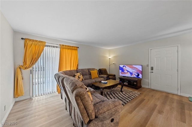 living room featuring baseboards and light wood finished floors