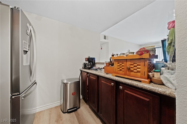 kitchen with visible vents, baseboards, light wood-type flooring, and stainless steel refrigerator with ice dispenser