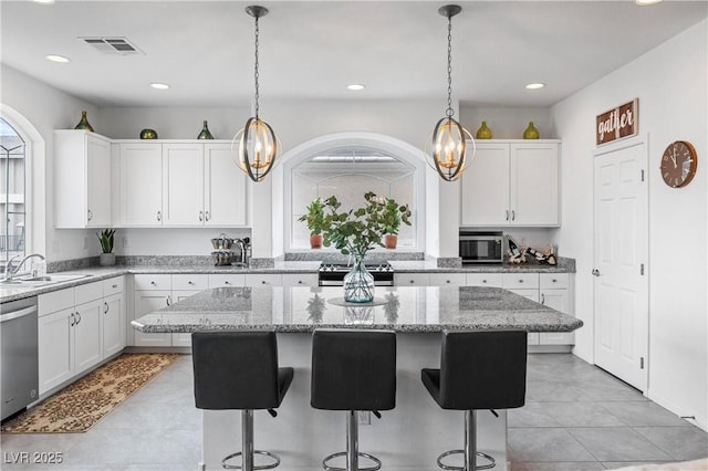 6346 Rock Strm Ln, Las Vegas, NV 89141 - kitchen with white cabinetry, stainless steel appliances, a sink, and a kitchen island