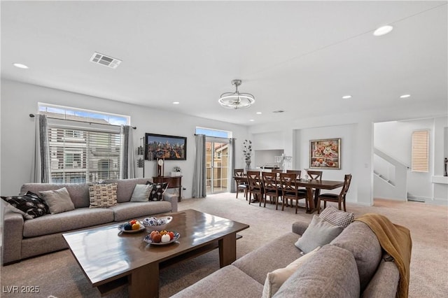 living room with an inviting chandelier, recessed lighting, visible vents, and light carpet