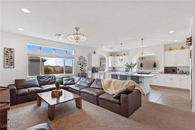 living room with recessed lighting, visible vents, an inviting chandelier, and light tile patterned flooring