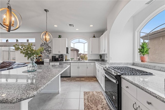 kitchen with visible vents, a sink, stainless steel dishwasher, black gas range oven, and an inviting chandelier