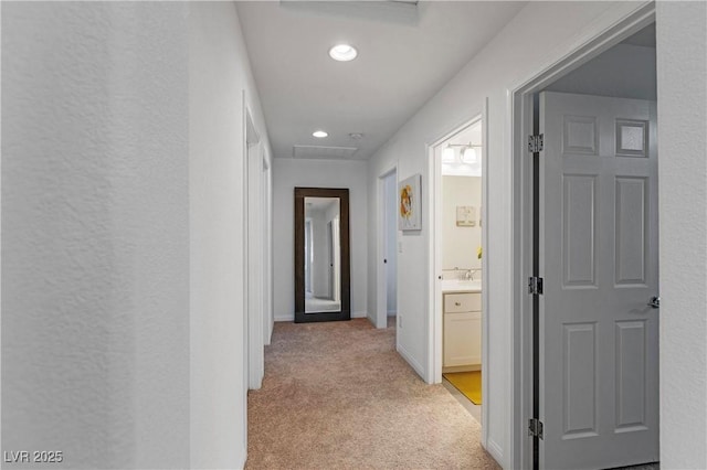 hallway with recessed lighting, baseboards, light carpet, and attic access