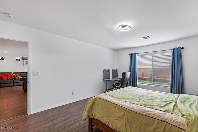 bedroom featuring visible vents, dark wood-style flooring, and baseboards