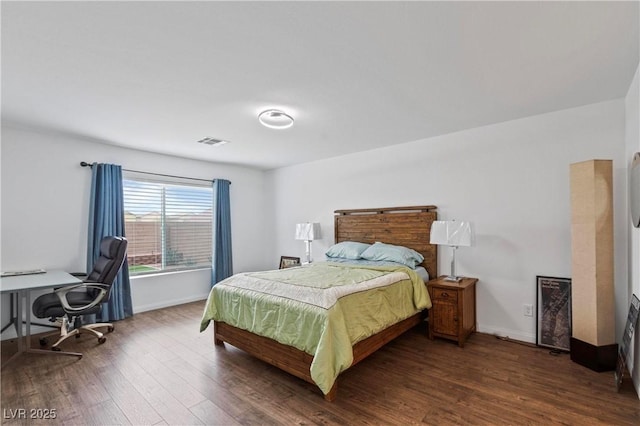 bedroom featuring visible vents, baseboards, and dark wood-style flooring